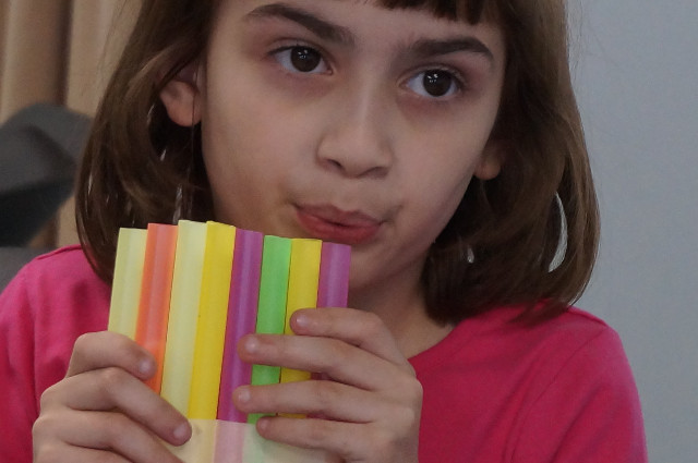 Blow across the top of each straw.