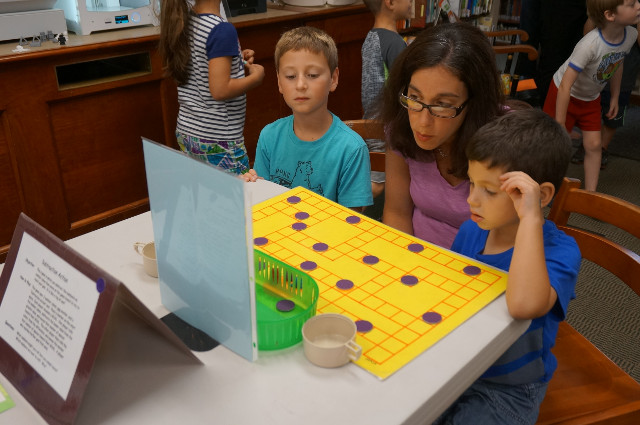 A family plays a math strategy game.