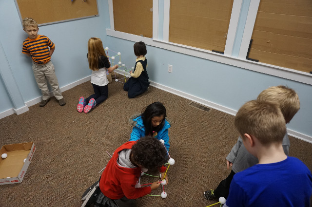 Buddies work together and try to figure out how to build a hexahedron.